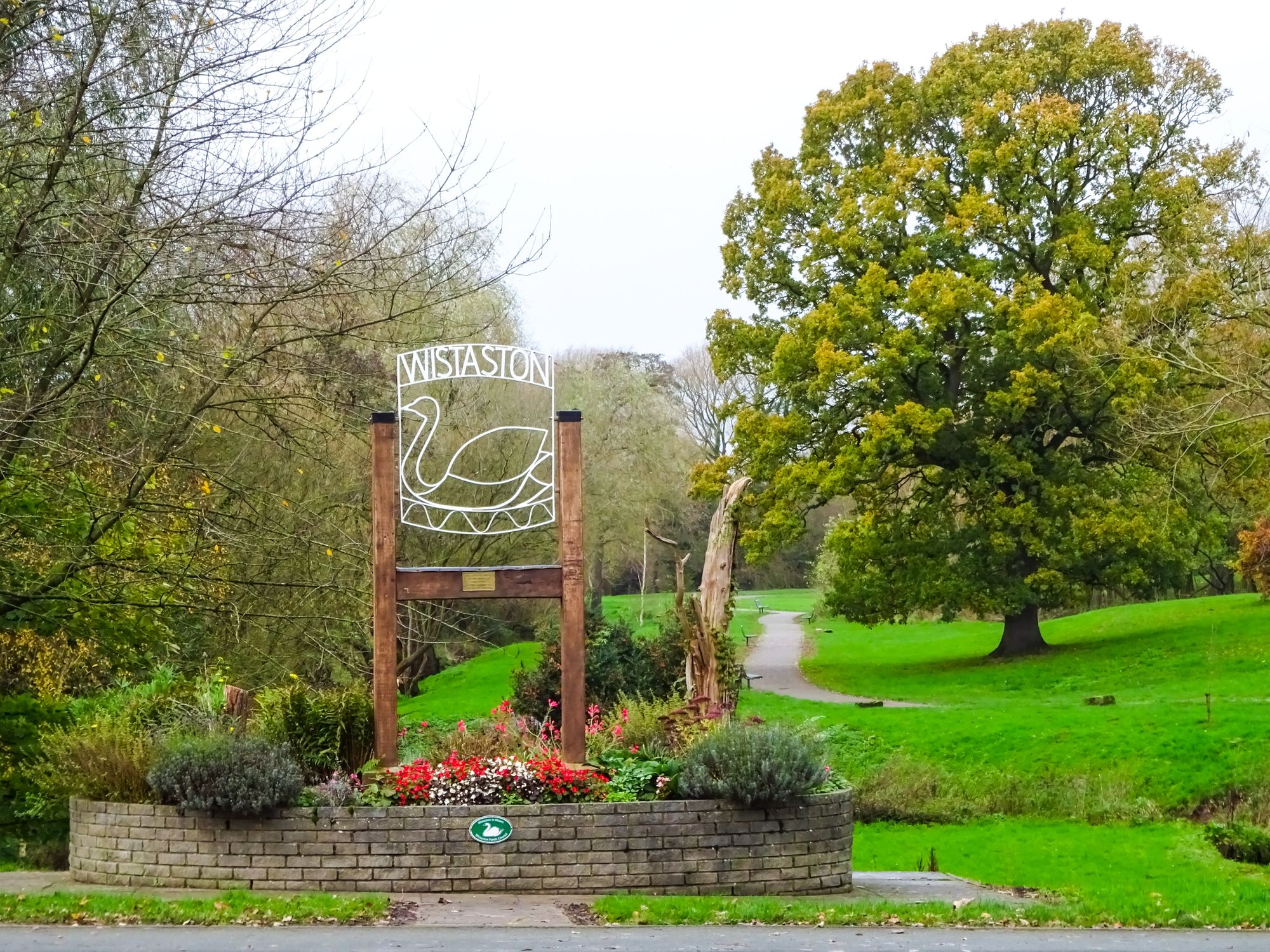 The Wistaston park entrance sign surrounded by flowers